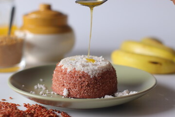 Ghee is being poured over the Navara rice puttu, a steamed rice cake, made of navara rice grains