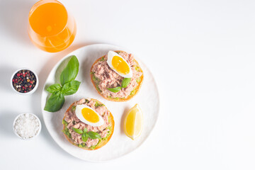 Two delicious tuna open sandwiches with avocado and boiled eggs. Tuna toast.