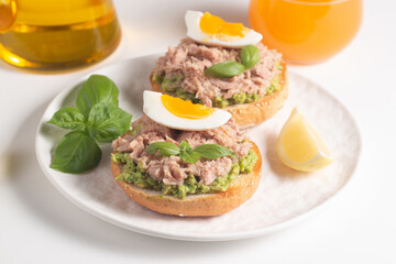 Two delicious tuna open sandwiches with avocado and boiled eggs. Tuna toast.