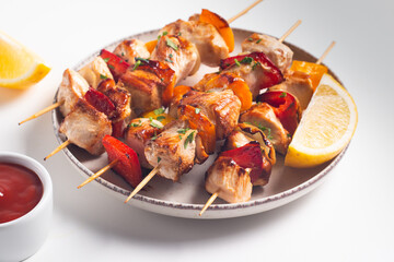Delicious grilled chicken skewers with capsicum, lemon, salad and ketchup on a plate over the table. Chicken kebab. Healthy food concept.