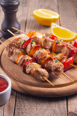 Delicious grilled chicken skewers with capsicum, lemon, salad and ketchup on a plate over the table. Chicken kebab. Healthy food concept.