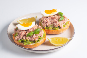 Two delicious tuna open sandwiches with avocado and boiled eggs. Tuna toast.