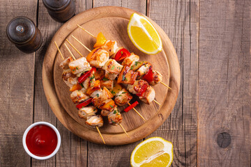 Delicious grilled chicken skewers with capsicum, lemon, salad and ketchup on a plate over the table. Chicken kebab. Healthy food concept.
