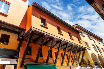 Medieval street in Bologna, with the distinctive architecture. The warm, orange buildings and detailed wooden structures capture the charm of this historic area.Bologna, Province of Ferrara, Italy
