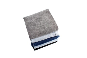 There is a stack of folded jeans on a white background.	