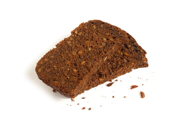 Pieces of black rye bread with sunflower seeds lie on a white background.	