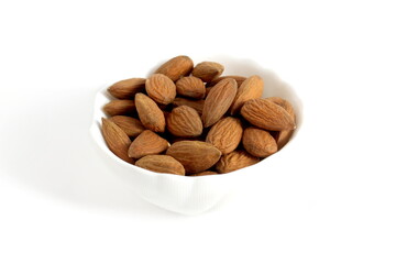 There is a white bowl with almonds on a white background.