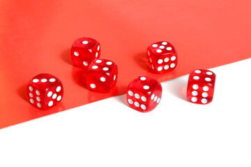 On a white red background lie red dice for the game.