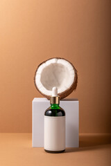 Cracked coconut on white stand with small bottle. Minimal mock up concept.