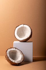 Cracked coconut with white cube on brown background. Summer tropical concept.