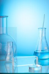 Science and medical background with lab glassware filled blue liquid and ribbed acrylic sheet decorated on light blue background. Space for products presentation.