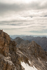 Fototapeta premium View from Zugspitze, Germany’s highest mountain, overlooking surrounding Alpine peaks, snowy ridges and valleys under a clear summer sky.
