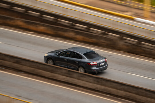 Grey Renault Fluence sedan driving, High angle panning shot, motion blur