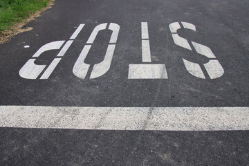 stop sign painted on asphalt