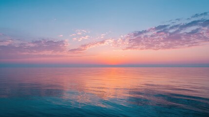 Obraz premium Soft hues of pink and orange blend in the sky as the sun sets over tranquil waters inviting peace.