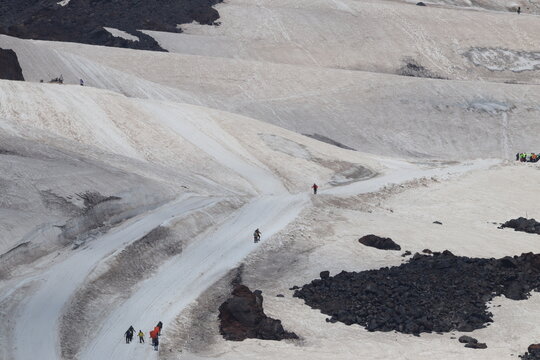 A chain of climbers ascending Mount Elbrus from a height of 4,100 m.