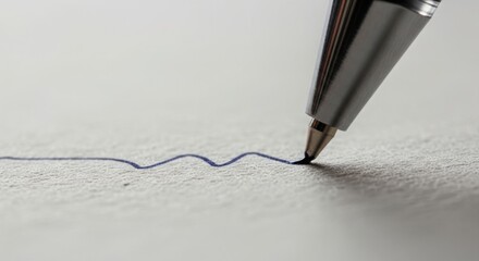 Close up of a ballpoint pen writing a wavy blue line on textured paper