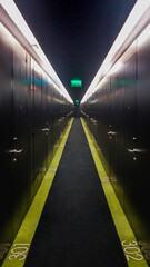 A corridor full of metal doors. Each one with a number on the floor. On the ceiling, a green exit...
