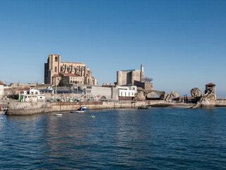 Fototapeta premium Castro urdiales harbor featuring gothic church and castle lighthouse