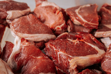 A close-up of raw, marbled beef cuts, showcasing rich red color and fat layers, ready for grilling or cooking in a farm-to-table experience.