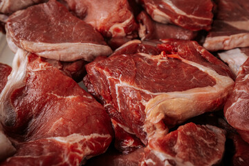 A close-up of raw, marbled beef cuts, showcasing rich red color and fat layers, ready for grilling or cooking in a farm-to-table experience.
