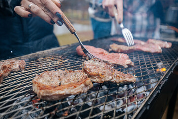 seasoned steaks sizzle on a grill over hot coals and open flame, capturing the essence of outdoor barbecue and flame-grilled flavor.