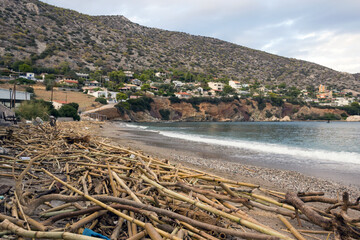 A sandy beach on an island in Greece is filled with a variety of debris brought by the waves of the sea. The concept of marine pollution, pollution of ocean water by plastic, garbage and human waste.