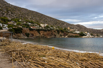 A sandy beach on an island in Greece is filled with a variety of debris brought by the waves of the sea. The concept of marine pollution, pollution of ocean water by plastic, garbage and human waste.