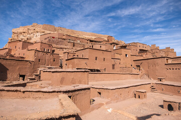 Obraz premium Close-up view of the traditional mudbrick architecture of Aït Benhaddou, Morocco, showcasing the earthen buildings clustered together under a bright blue sky.