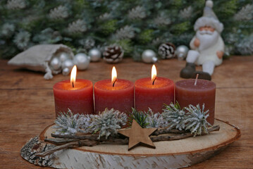 Third Advent: Decoration with four brown Advent candles, fir branches and Christmas baubles with space for a text.