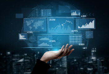 A hand reaches out to interact with a futuristic digital interface showcasing data visualization and analytics over a night cityscape, symbolizing modern technology in finance. Scalp