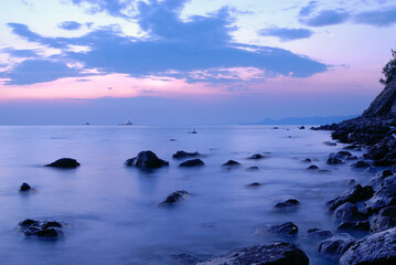 Beautiful atmospheric sunset with warm orange and pink hues, illuminating the sky and landscape in soft glowing light.