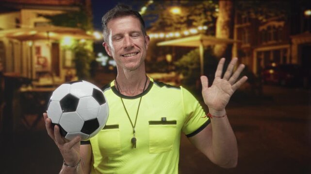 Man referee holding soccer ball with palm raised on street in neon yellow jersey and whistle visible; fair play authority.