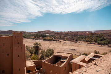 Aerial view of the historic fortified village of Aït Benhaddou in Morocco, featuring traditional mudbrick architecture against a vast desert landscape.