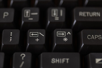 Close-up of vintage computer keyboard showing arrow keys, symbols, and command markings, ideal for retro tech projects, hardware documentation, and computing history materials.
