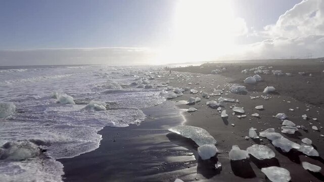 Aerial view of black sand beach with iceberg ice pieces on the shore also called diamond beach