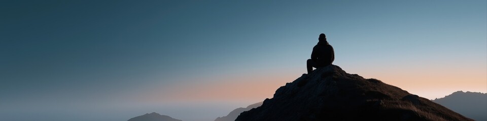 Silhouette of person on mountain at sunset