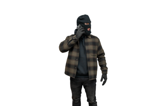Criminal wearing balaclava speaking on smartphone for bank robbery plan on transparent background