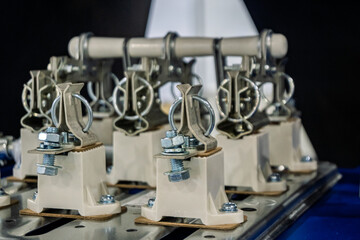 Close-up of industrial electrical fuse holders or disconnect switches with ceramic insulators and metal contacts, mounted on a panel. Essential for power distribution and circuit protection.