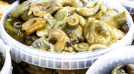 Pickled mushrooms sold on the market. Marinated mushrooms, appetizer of pickled mushrooms