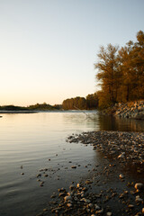 Calm riverbank at sunset in autumn
