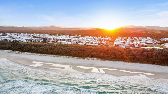 Sunset drone aerial view of beachfront properties at Salt Kingscliff overlooking coastline and ocean - Powered by Adobe