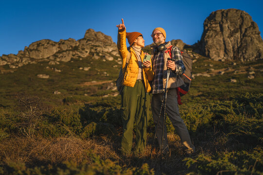 Happy diverse couple hiking in mountains exploring nature