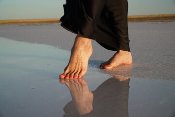 A view of women's feet near the water on a salt lake