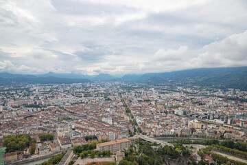 Fototapeta premium Aerial view of Grenoble old town seen from Bastille Fort, Auvergne-Rhone-Alpes region, France, Europe. View from above on the Isere Valley in the French Pre-Alps. Chartreuse Belledonne mountain range