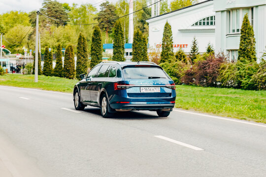 Skoda Superb III Combi car moving on the street. Estate vehicle driving along street in city with blurred background