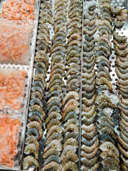 Raw shrimp and seafood displayed on ice in a market counter