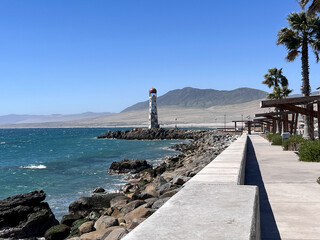 Seaside promenade in Huasco, Chile, featuring the iconic lighthouse Faro de Huasco. Tall palm trees, and a peaceful coastal atmosphere by sunny day making perfect travel and tourism concept. © K&M FEHR