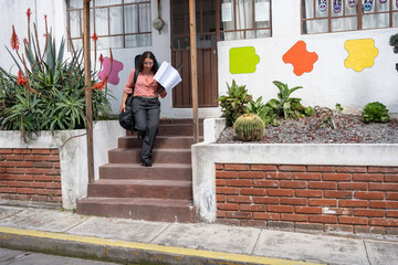 Guitar teacher leaving the classroom after finishing her private lessons, carrying her instrument and materials. End of workday, education, music teaching, professional lifestyle