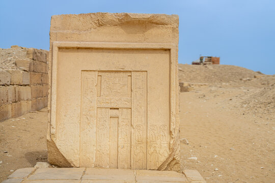 Ancient limestone false door standing in the desert necropolis of Saqqara, Egypt